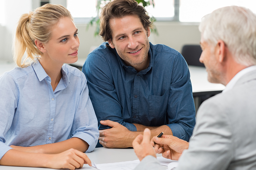 Businessman explaining loan policy to young couple. Happy couple